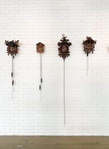four cuckoo clocks displayed on a wall