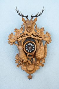 a cuckoo clock with a deer carved into it