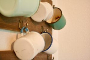 vintage enamelware cups arranged on hooks