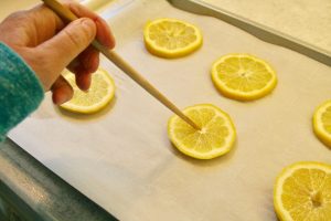 poking holes in lemon slices for garland
