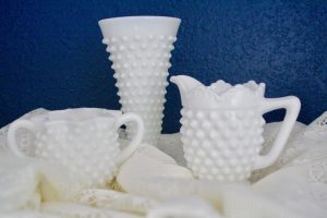 a grouping of white hobnail glass
