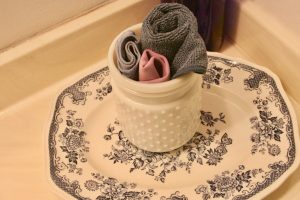 small white hobnail jar as towel storage