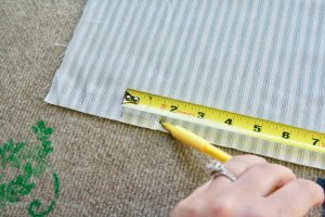 measuring the width of fabric strips with tape measure