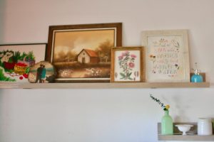vintage art and decor displayed on a picture rail