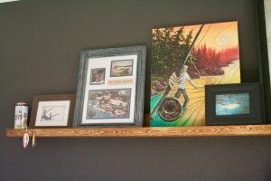 a picture rail with various pieces of decor on it.