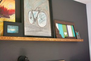 various art displayed on a picture rail