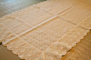 a vintage table runner with lace edges and green dots