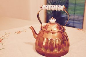 vintage copper teapot on vintage linen
