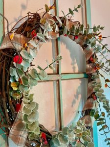 a diy grapevine wreath hanging on an old window