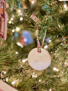 a homemade clay ornament on a Christmas tree with stamps