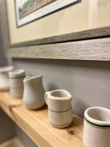 collection of vintage cafe creamers styled on a shelf