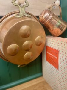 vintage copper cookware styled on a peg rack