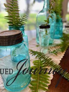 vintage jars grouped together with fresh ferns