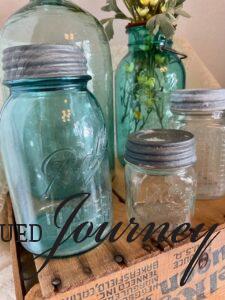 vintage glass jars grouped together on a wooden crate