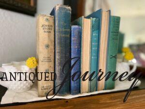 a row of vintage blue books styled on a mantel for Summer