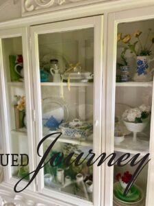 a hutch styled for summer with vintage decor