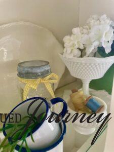 vintage milk glass used in a hutch for Summer decor