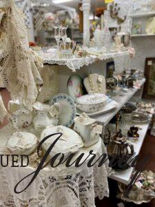 an antique mall booth full of ironstone and other vintage decor