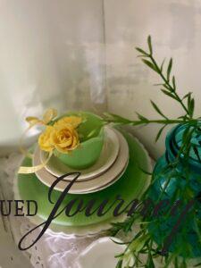 a vintage jadeite teacup with faux yellow flowers inside