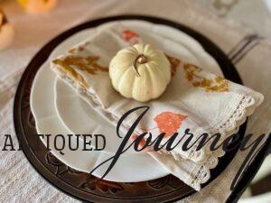 a stamped leaf napkin with a small white pumpkin on top