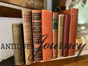 a row of antique and vintage books styled across a mantel for Thanksgiving decor