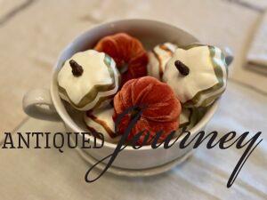 a thrifted ironstone tureen filed with faux pumpkins for fall decor