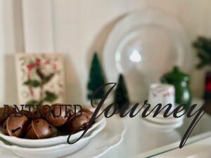 vintage Christmas vignette with stacked platters, plates, and creamers. 