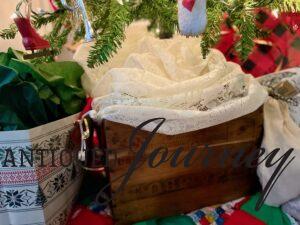 a vintage thrifted crate and table linen used as a tree skirt for a Christmas tree