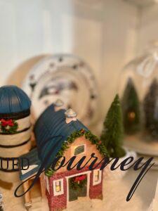 a light up Christmas barn styled in a hutch for the season