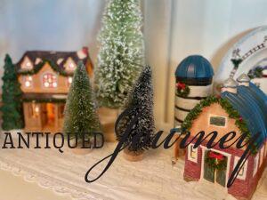 thrifted Christmas houses used in a hutch display for the holiday season