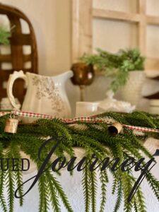 vintage items such as milk glass and ironstone used with a faux garland for a Christmas display