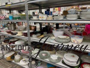 thrift store shelving full of dishes that I'm not buying in 2025