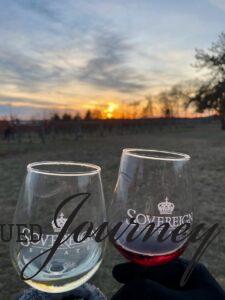 having a glass of wine at a vineyard at sunset