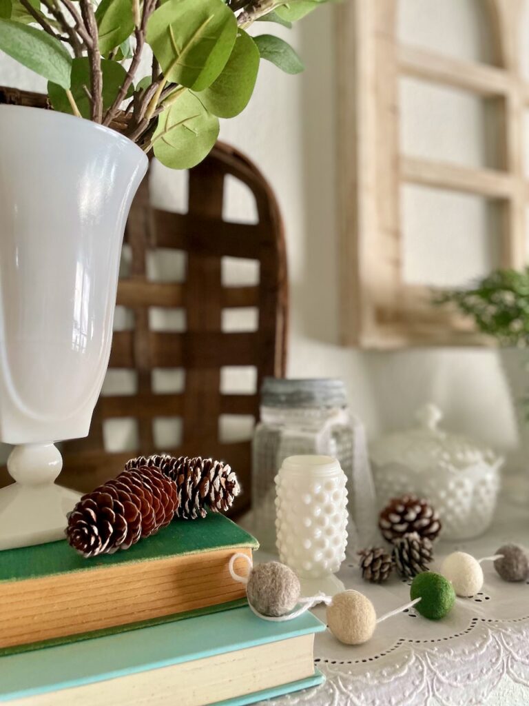 decorating a living room shelf for winter with vintage milk glass