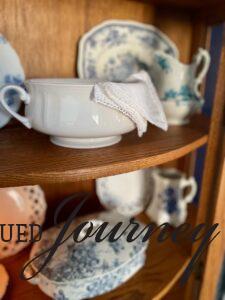 vintage blue and white dishes styled in a curio cabinet