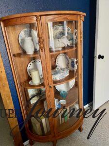 an antique curio cabinet placed in a bedroom