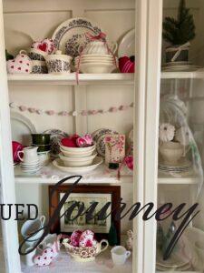 a finished hutch display filled with vintage and thrifted decor for valentines day