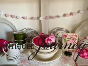 stacking vintage bowls in a hutch for cute valentines decor 