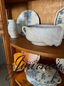 layering vintage decor in a curved cabinet
