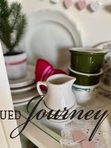 vintage cups and creamers styled in a valentines day themed hutch