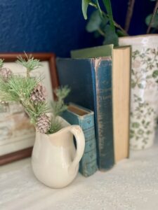 vintage decor styled on a dresser with books and ironstone. How vintage decor contributes to simple living
