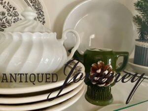 a vintage green flower frog styled in a hutch with vintage dishes 