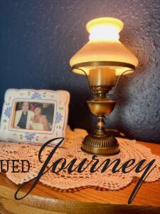 a vintage lamp styled on top of a curio cabinet with glass doors