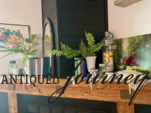 a fireplace mantel decorated for summer with vintage finds