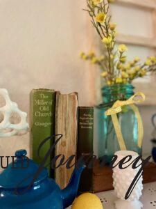 vintage books styled for summer on a living room shelf