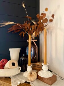 a vintage glass amber bottle with faux gold stems for fall decor