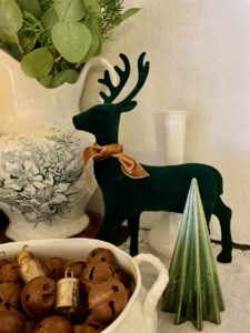 flocked green deer styled on a Christmas mantel