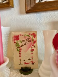 antique Valentine postcard on a shelf for Valentines day decor