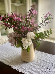 using decor you already have for spring decorating like a vintage enamel kettle as a vase
