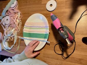 gluing ribbon on ironstone platters for DIY easter decor